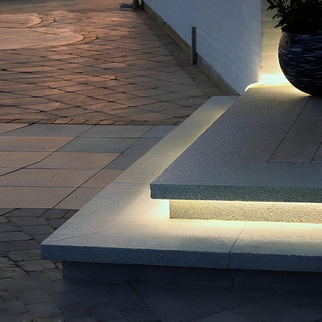 Outdoor embedded LED light strips illuminating a cozy outdoor seating area.